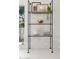 Chic kitchen decor includes a black metal shelving unit, dishware, and hanging greenery at 5103 E Juniper Ave, Scottsdale, AZ 85254