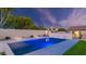 Backyard pool featuring in-pool seating, stone accents, backyard lighting, and privacy fence at 5103 E Juniper Ave, Scottsdale, AZ 85254