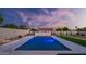 Backyard pool featuring custom stone waterfall, lush landscaping and a beautiful sunset at 5103 E Juniper Ave, Scottsdale, AZ 85254