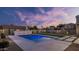 Backyard pool featuring custom stone waterfall and lush landscaping with a beautiful sunset at 5103 E Juniper Ave, Scottsdale, AZ 85254