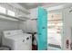 Bright laundry room with white appliances, practical storage, and exterior access at 5317 E Colby St, Mesa, AZ 85205