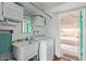 Well-lit laundry room with utility sink, washer, and dryer, providing convenience at 5317 E Colby St, Mesa, AZ 85205