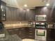 Well-equipped kitchen featuring stainless steel appliances, granite countertops, and rich, dark wood cabinetry at 5350 E Deer Valley Dr # 3267, Phoenix, AZ 85054