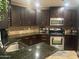 Well-equipped kitchen featuring stainless steel appliances, granite countertops, and rich, dark wood cabinetry at 5350 E Deer Valley Dr # 3267, Phoenix, AZ 85054