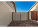 Enclosed gravel backyard with a metal gate between stucco walls at 6244 E Inglewood St, Mesa, AZ 85205