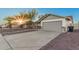 Exterior view of home showing driveway leading to two-car garage with desert landscaping at 6244 E Inglewood St, Mesa, AZ 85205