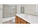 Neutral-toned bathroom with a single sink vanity, tiled flooring, and sliding glass doors on tub/shower at 7464 E Lompoc Ave, Mesa, AZ 85209