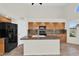 Lovely kitchen with an island, dark appliances, wooden cabinets, and tiled floors at 7464 E Lompoc Ave, Mesa, AZ 85209
