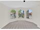 Bright room featuring carpeted floors and a view through arched windows at 7464 E Lompoc Ave, Mesa, AZ 85209