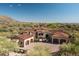 Majestic aerial view of luxury estate showcasing tile roof, multiple garages, and lush desert landscaping at 7753 E Whisper Rock Trl, Scottsdale, AZ 85266