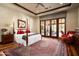 Primary bedroom with a four-poster bed, seating area, and access to an outdoor patio at 7753 E Whisper Rock Trl, Scottsdale, AZ 85266