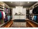 Spacious walk-in closet with custom shelving, a center island, and a chandelier for added elegance at 7753 E Whisper Rock Trl, Scottsdale, AZ 85266