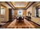 Formal dining room featuring a chandelier, coffered ceilings, and a large window with natural light at 7753 E Whisper Rock Trl, Scottsdale, AZ 85266