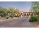 Beautiful desert home with a large driveway, lush landscaping, and a well-maintained exterior at 7753 E Whisper Rock Trl, Scottsdale, AZ 85266