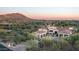 Desert home featuring manicured landscaping, tile roof, multiple garage bays, and mountain views at 7753 E Whisper Rock Trl, Scottsdale, AZ 85266