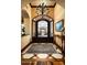 Elegant foyer featuring decorative wrought iron doors, hardwood floors, chandelier, and custom woodwork at 7753 E Whisper Rock Trl, Scottsdale, AZ 85266