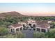 Stunning home showcasing a red tile roof, circular drive, three-car garage, and beautiful desert landscaping at 7753 E Whisper Rock Trl, Scottsdale, AZ 85266
