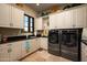 Functional laundry room with modern washer and dryer, ample counter space, and built-in cabinets at 7753 E Whisper Rock Trl, Scottsdale, AZ 85266
