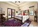 Spacious main bedroom with large bed frame, accent rug, and access to the outdoors through glass doors at 7753 E Whisper Rock Trl, Scottsdale, AZ 85266