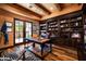 Home office boasts wood floors, built-in bookshelves, a large desk, and outdoor views at 7753 E Whisper Rock Trl, Scottsdale, AZ 85266