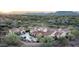 Expansive desert home featuring an outdoor living space, fire pit, lush landscaping, and mountain views at 7753 E Whisper Rock Trl, Scottsdale, AZ 85266