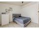 Neutral bedroom features a queen-sized bed, white dresser, and tile flooring at 8404 W Coronado Rd, Phoenix, AZ 85037