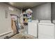 Functional laundry area features washer, dryer and storage shelves with home cleaning supplies at 8404 W Coronado Rd, Phoenix, AZ 85037