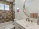 Cozy bathroom features a shower-over-tub, mosaic tile, and round decorative mirror at 8423 E Heatherbrae Dr, Scottsdale, AZ 85251