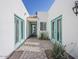 Inviting entrance way with quaint landscaping, sky-blue doors and a brick walkway at 8423 E Heatherbrae Dr, Scottsdale, AZ 85251