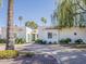 Stunning white single-story home featuring an inviting light blue door and meticulous landscaping at 8423 E Heatherbrae Dr, Scottsdale, AZ 85251