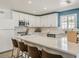 A stylish eat-in kitchen is furnished with white cabinetry, stainless appliances, and counter seating at 8423 E Heatherbrae Dr, Scottsdale, AZ 85251