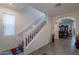 Inviting hallway with staircase, wood-look tile flooring, and arched entryway to the dining area at 8905 W Jefferson St, Tolleson, AZ 85353
