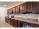 Well-equipped kitchen with dark wood cabinets, granite counters, and stainless steel appliances at 8905 W Jefferson St, Tolleson, AZ 85353