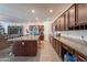 Open-concept kitchen with granite countertops, stainless steel appliances, island with bar seating, and open living area at 8905 W Jefferson St, Tolleson, AZ 85353