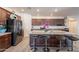 Bright kitchen with a granite island, dark wood cabinets, stainless steel appliances, and bar seating at 8905 W Jefferson St, Tolleson, AZ 85353