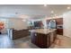 Open-concept living room and kitchen with wood-look tile flooring, an island, and a cozy sectional sofa at 8905 W Jefferson St, Tolleson, AZ 85353