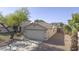 Well-kept one story home, featuring a two-car garage, desert landscaping, and mature trees at 12046 W Flores Dr, El Mirage, AZ 85335