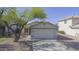 Charming single-story home with a well-maintained front yard, a wide driveway, and a two-car garage at 12046 W Flores Dr, El Mirage, AZ 85335