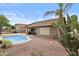 Lush backyard featuring a kidney-shaped pool, patio area, and desert landscaping with cacti and palm trees at 12214 W Madison St, Avondale, AZ 85323