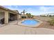 Backyard with a pool, covered patio with outdoor furniture, and desert-style landscaping at 12214 W Madison St, Avondale, AZ 85323