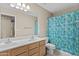 Bathroom featuring double sinks, white vanity, and a shower with a vibrant, patterned curtain at 12214 W Madison St, Avondale, AZ 85323