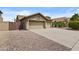 Well-maintained home exterior with a spacious driveway and three-car garage, enhanced by tidy landscaping at 12214 W Madison St, Avondale, AZ 85323