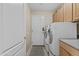 Well-lit laundry room with washer, dryer, cabinetry, utility sink, and access to the exterior at 12214 W Madison St, Avondale, AZ 85323