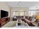 Comfortable living room features a plush brown sofa, media center, and neutral tones at 12214 W Madison St, Avondale, AZ 85323