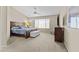 Spacious main bedroom with a plush bed, ceiling fan, large window, and comfortable furnishings at 12214 W Madison St, Avondale, AZ 85323