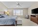 Bright main bedroom with a king bed, ceiling fan, scenic views, and cozy seating arrangement at 12214 W Madison St, Avondale, AZ 85323