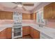 Well-lit kitchen with wooden cabinets, and updated appliances for seamless meal preparation at 131 N Higley Rd # 117, Mesa, AZ 85205