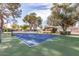Outdoor blue tennis court with a green playing surface in a community at 131 N Higley Rd # 117, Mesa, AZ 85205