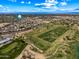 Aerial showcasing the golf course views with neighborhood nearby under sunny skies and scattered clouds at 13857 W Windsor Ave, Goodyear, AZ 85395