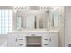 Bathroom featuring double vanity, large mirror, and glass block window for natural light at 13857 W Windsor Ave, Goodyear, AZ 85395